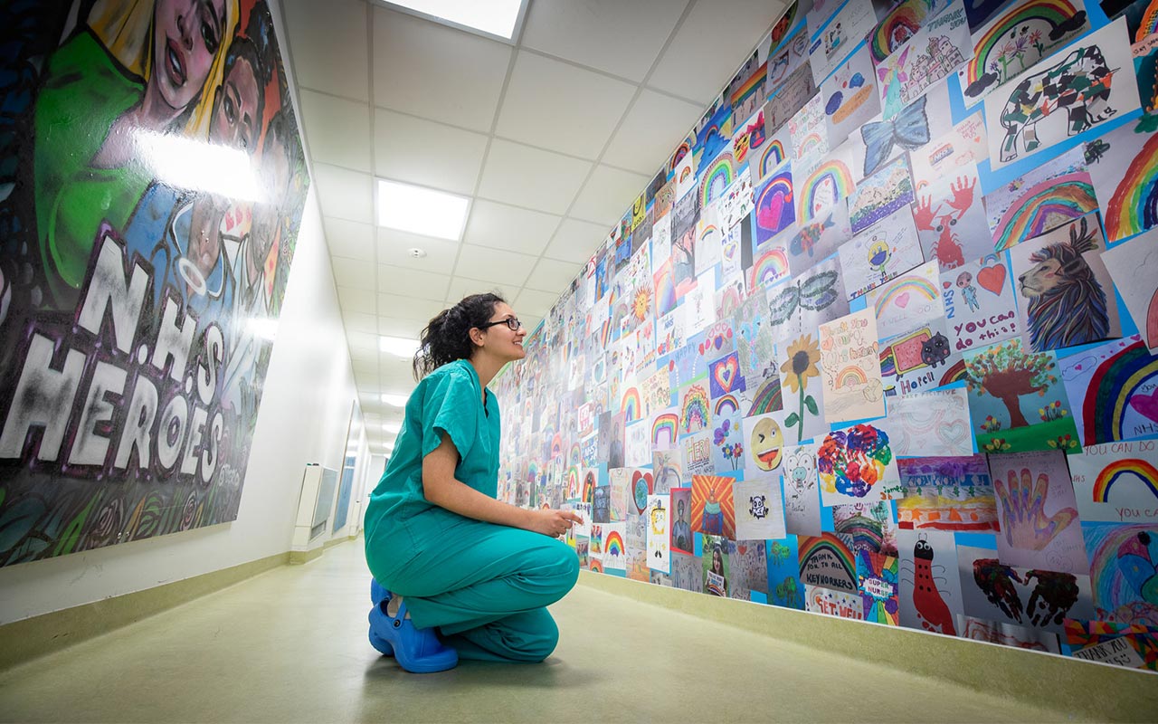 nurse looks at artwork on wall at Oander and the Roayl Free Charity re decoration of ICU ward